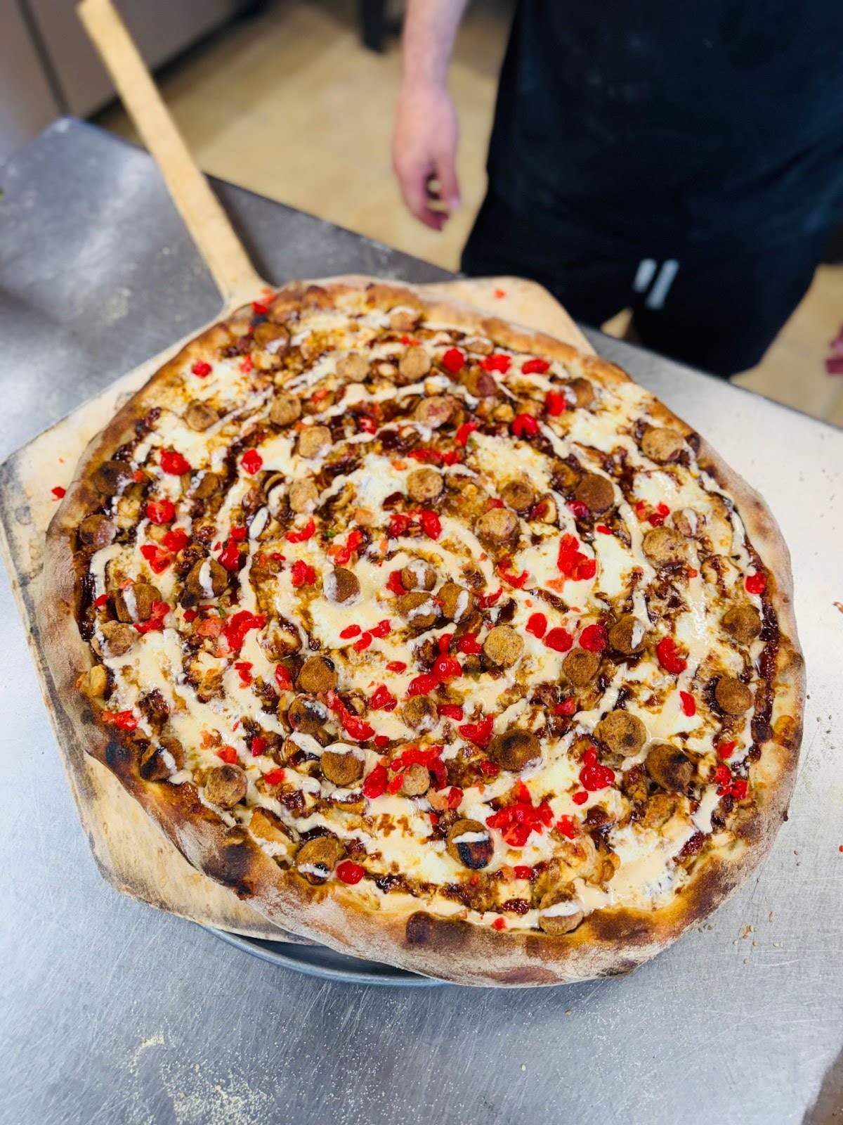 Exclusive birthday collaboration pizza at Ocean Casino Resort in Atlantic City, featuring sausage, peppers, and creative toppings.