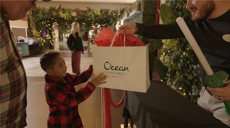 Child gets a special gift at Santa's Hideaway Adventure