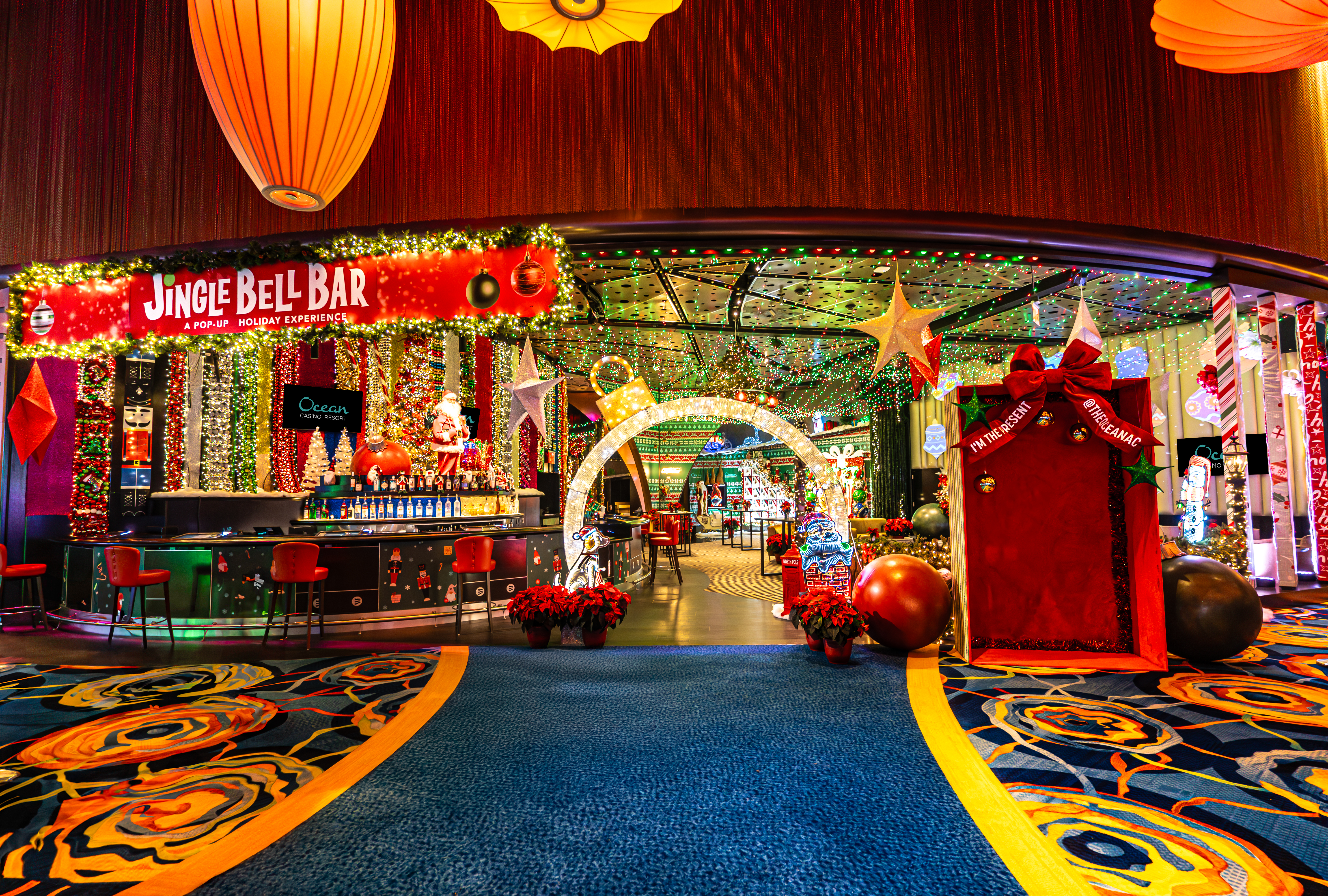 Entrance to the Jingle Bell Bar holiday pop-up at Ocean Casino Resort in Atlantic City, featuring twinkling lights and festive décor.