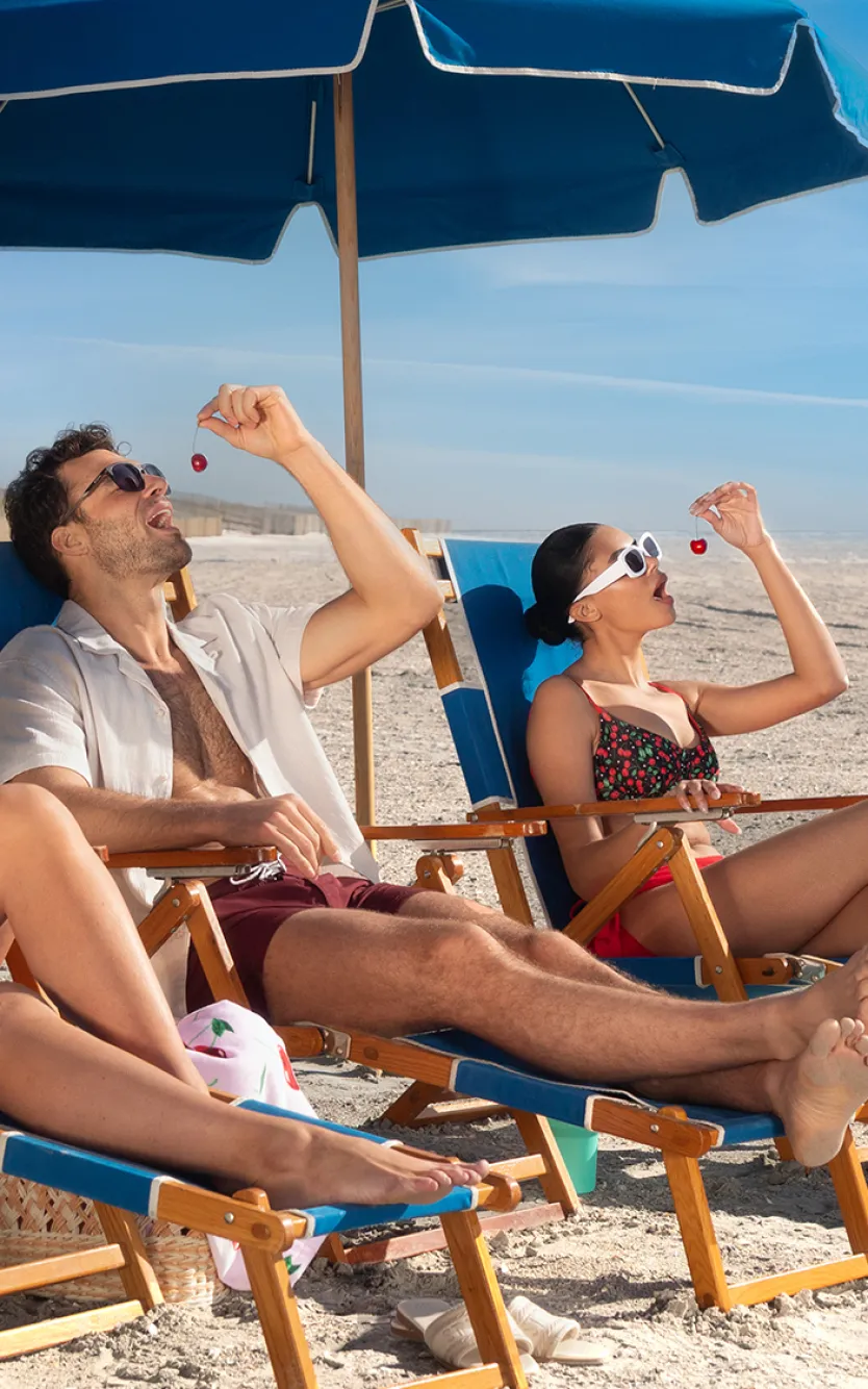 Three friends sitting on the beach in front of Ocean Casino Resort
