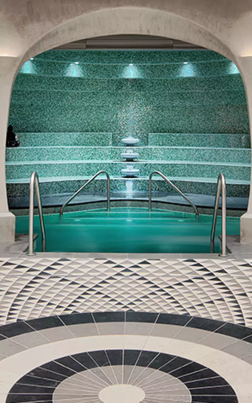 Tiled lounge area in with archways leading to spa pool
