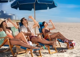 Three friends sitting on the beach in front of Ocean Casino Resort